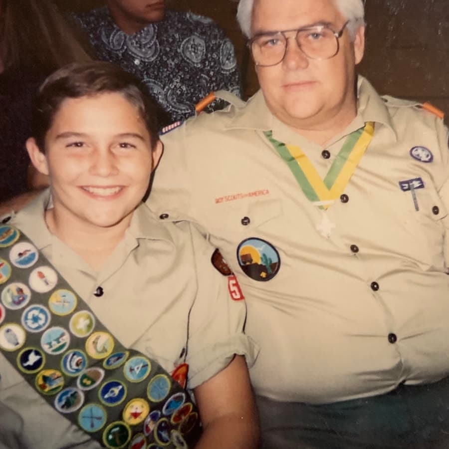 Ryan as a boy in his Scout uniform, sitting with his dad